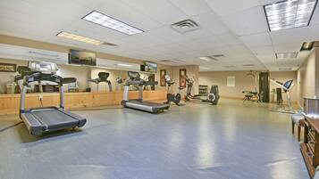A gym with treadmills, stationary bikes, and a rowing machine.