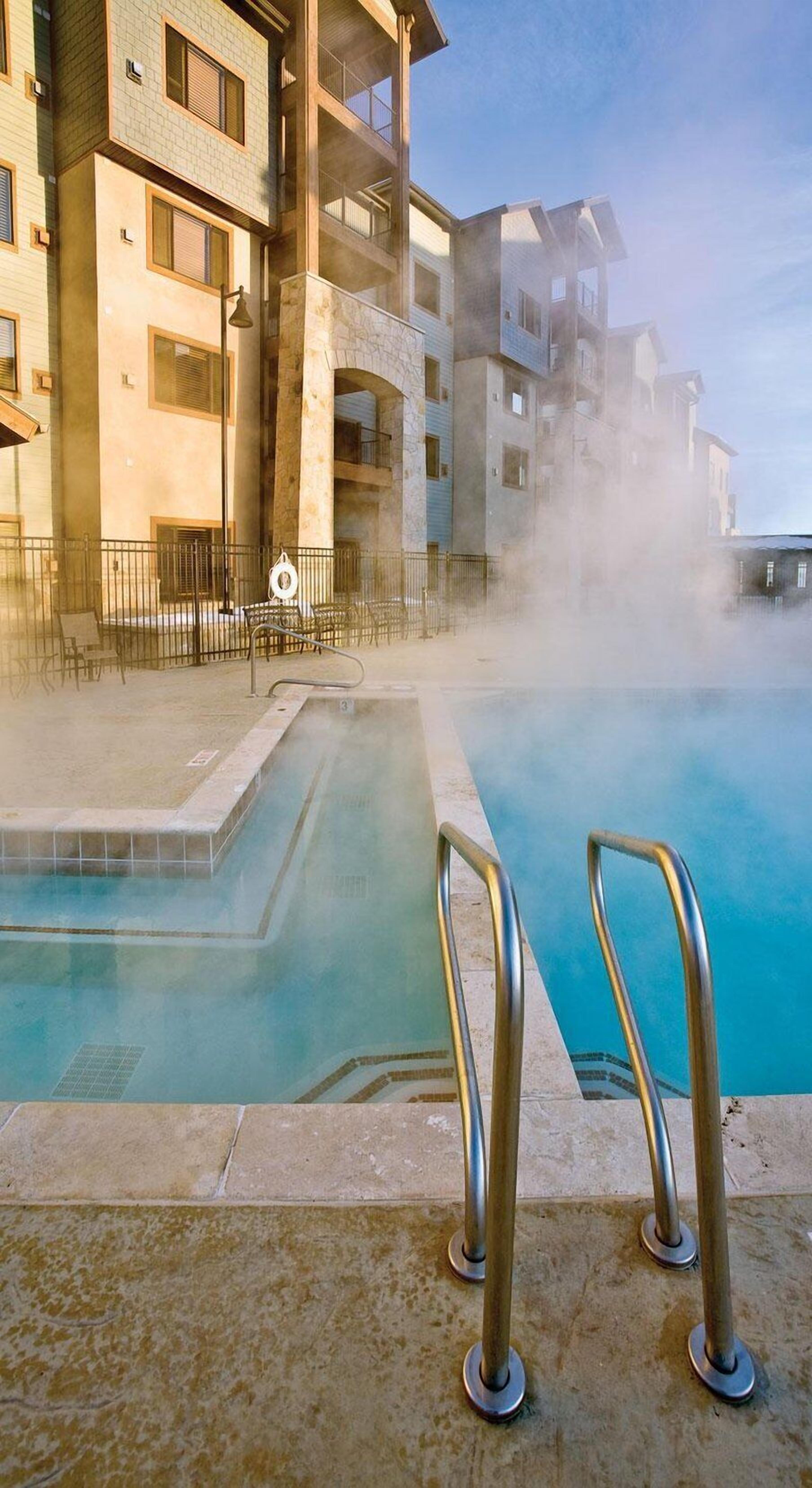 A pool area with a clear view of a building in the background.