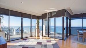 Un balcón amplio con ventanas grandes que ofrecen vista a la ciudad y al mar.