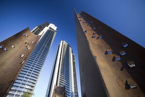 Two tall buildings with modern architecture, featuring large windows and a unique design with cut-out patterns. - Mantra Circle on Cavill (Surfers Paradise)