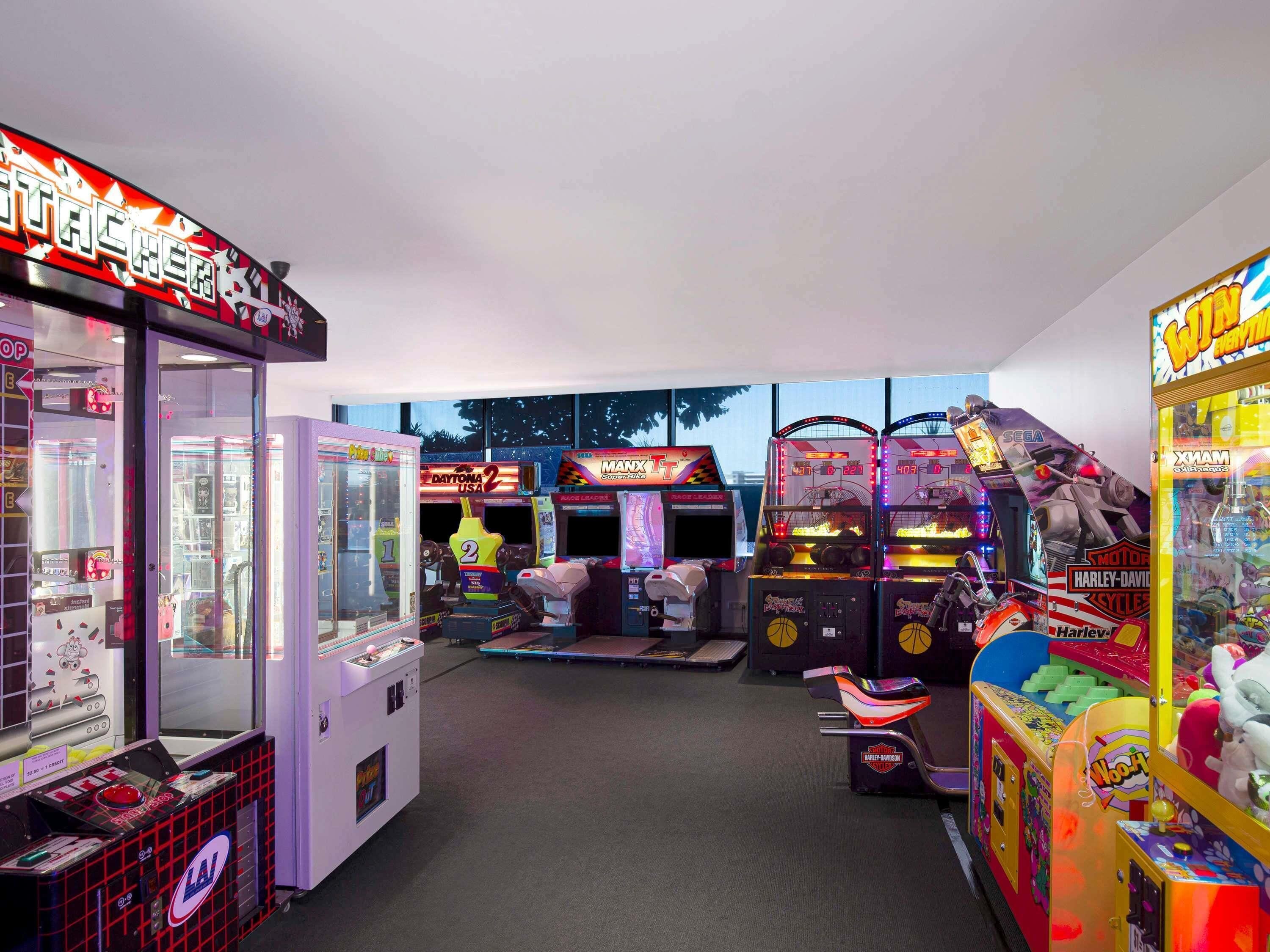 An arcade with various gaming machines, including a Harley-Davidson-themed game.