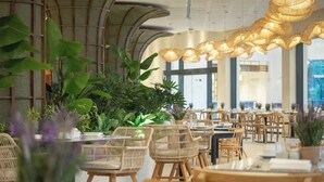 A restaurant with wicker furniture and potted plants. - Catalonia Bayahibe – All Inclusive (San Rafael del Yuma)