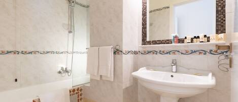 Un baño con bañera, lavabo y ducha.