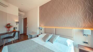 Une chambre d’hôtel moderne, dotée d’un grand lit, d’un bureau et d’une chaise.