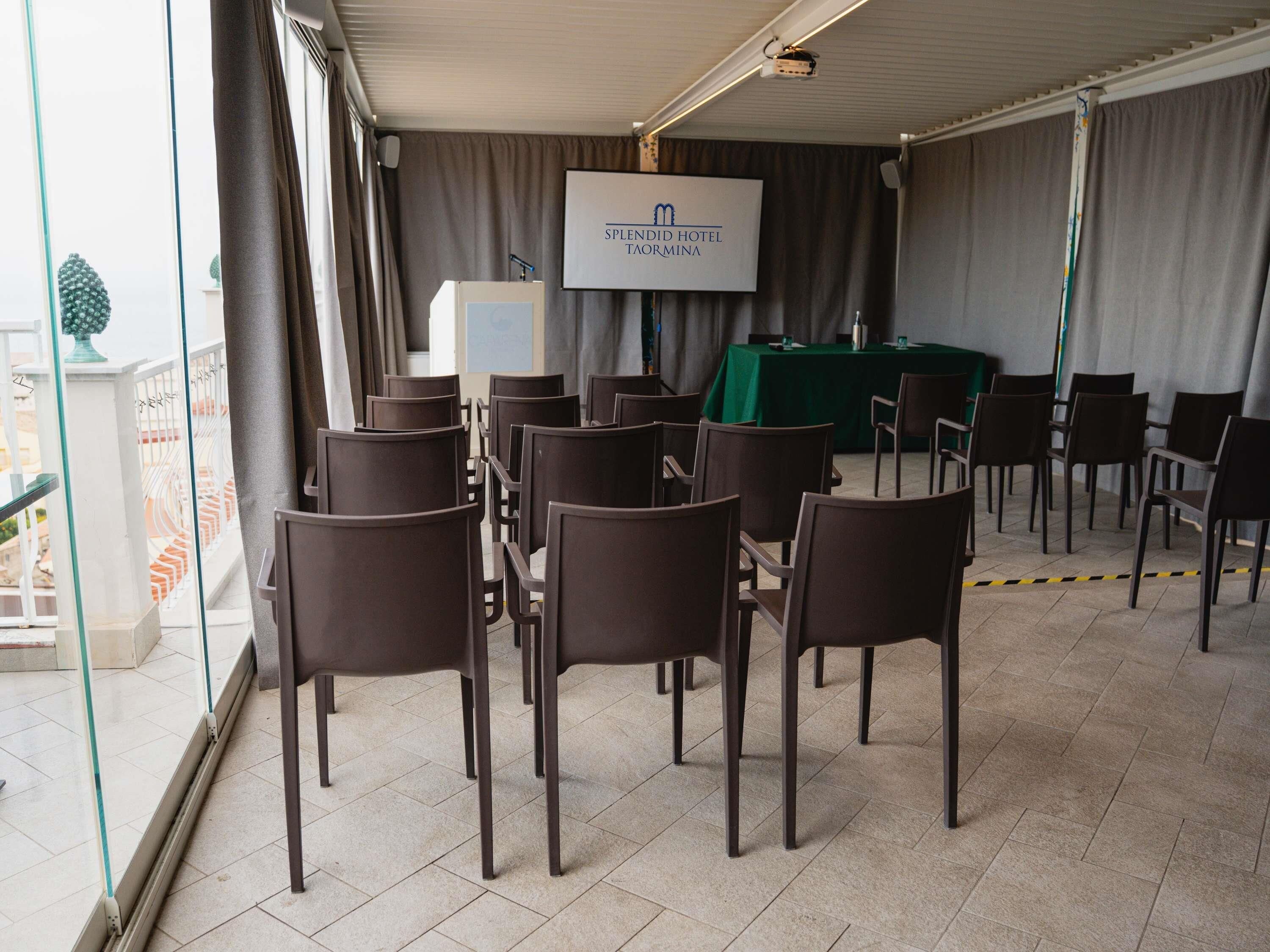 A conference room with a projector screen displaying 'SPLENDID HOTEL TAMAMINA' at the top.