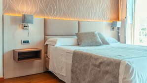 Quarto bem arrumado com cama, abajures e estante embutida.