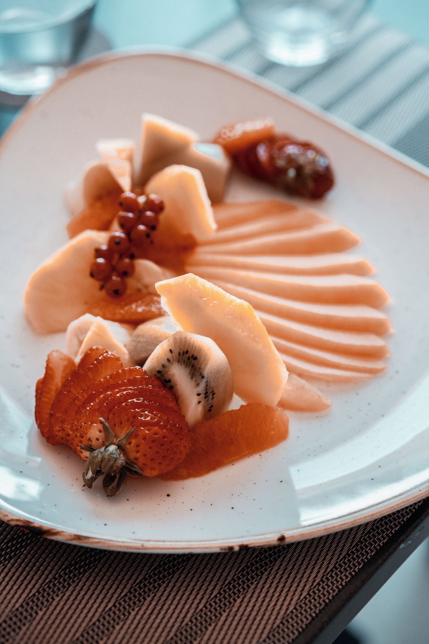 A plate of assorted fruits and a drizzle of sauce.