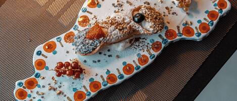 A uniquely shaped plate with a dessert on it, placed on a textured mat.