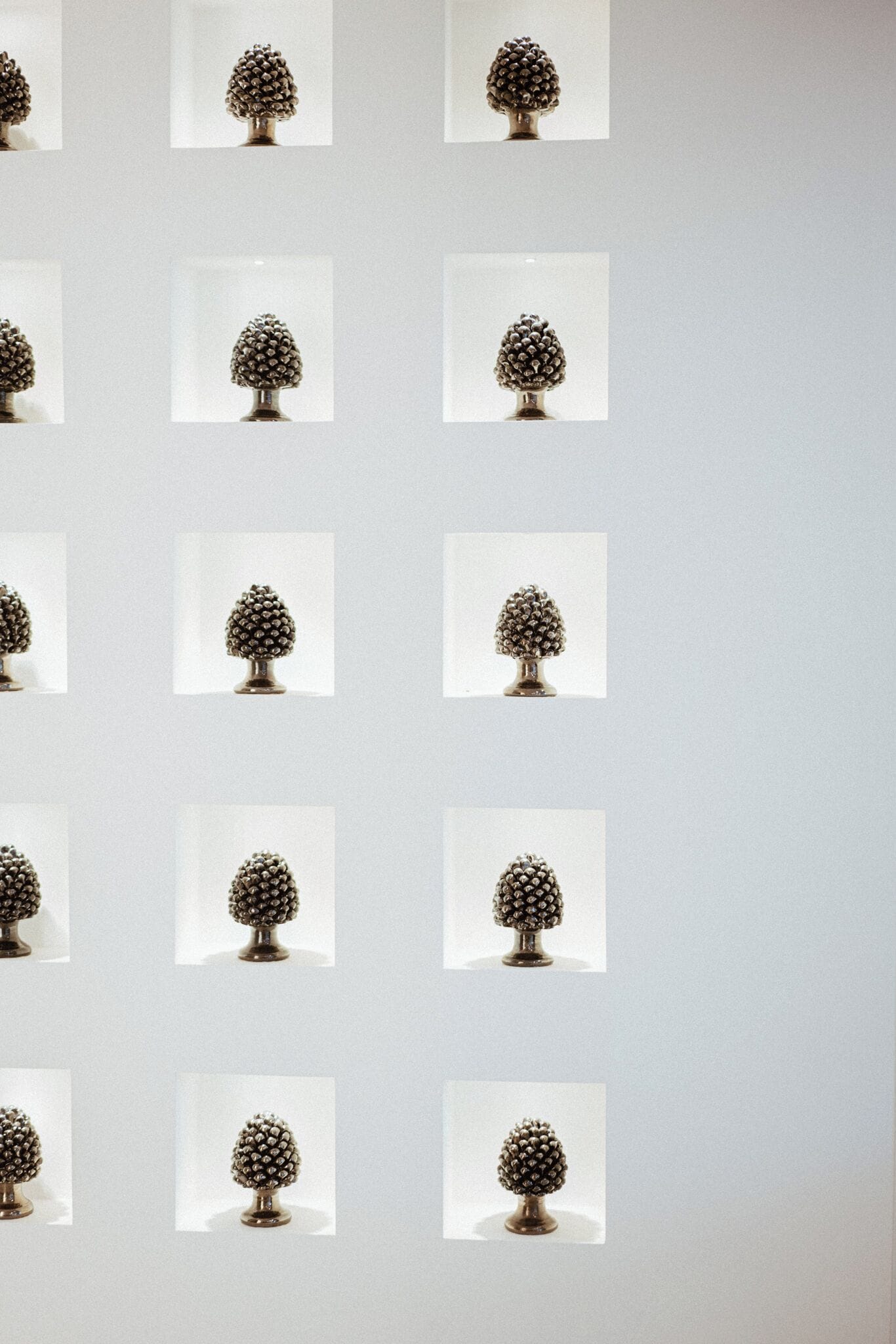 Eine Wand mit mehreren quadratischen Rahmen, jeweils mit einem dekorativen Metallbaum.