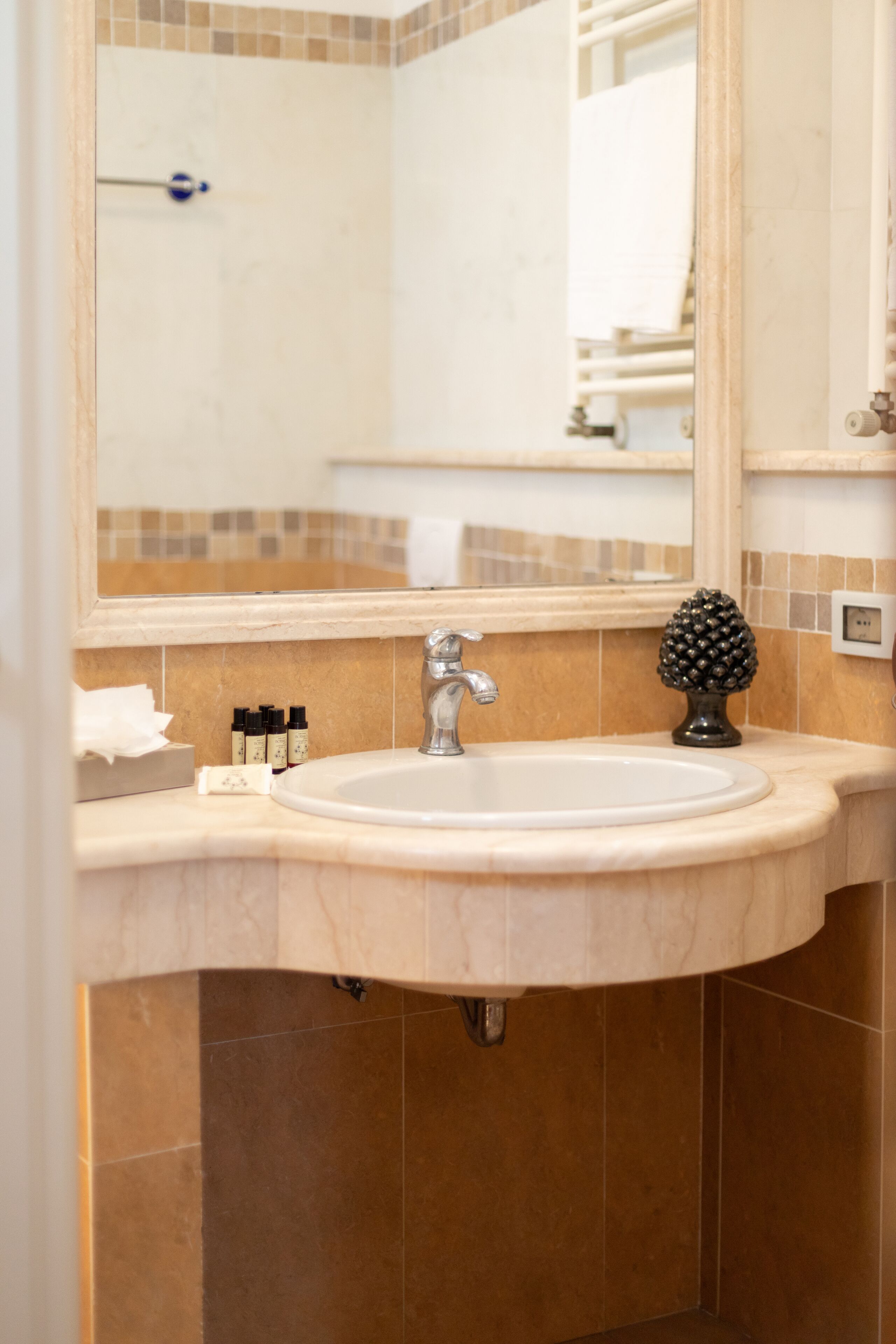 Un baño con lavamanos, espejo y artículos de aseo.