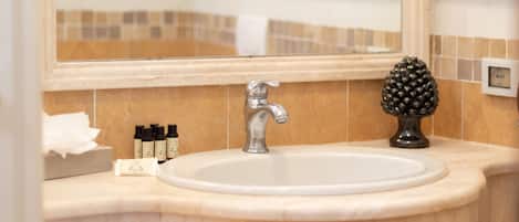 A bathroom with a sink, mirror, and toiletries.