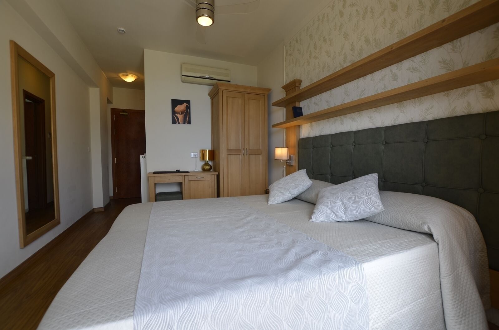 Une chambre avec un grand lit, un bureau et une armoire.