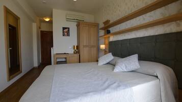 Une chambre avec un grand lit, un bureau et une armoire.