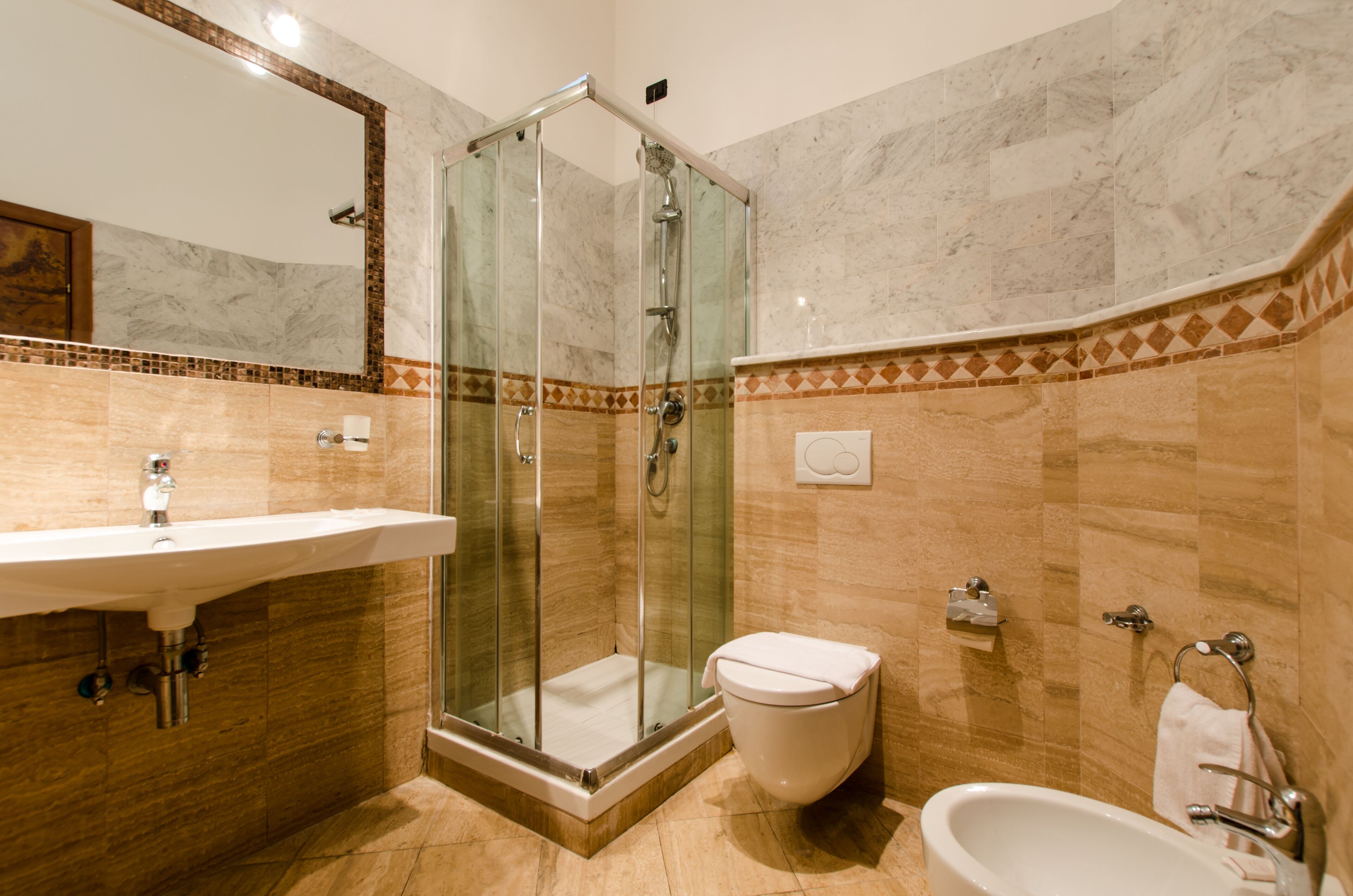 A bathroom with a glass-enclosed shower, a sink, a toilet, and a bathtub.