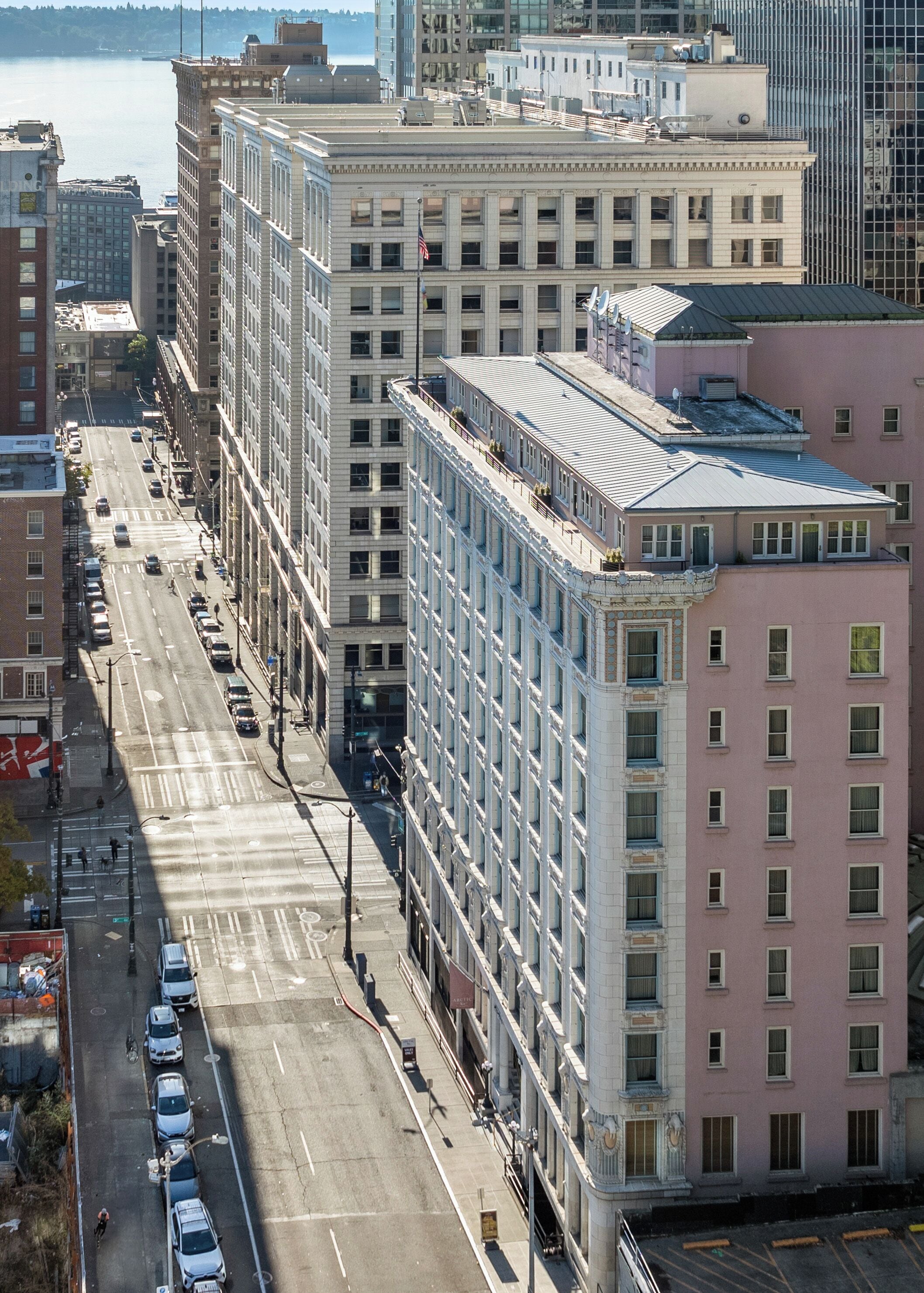 A multi-story building with a flat facade, large windows, and a parking lot in front.