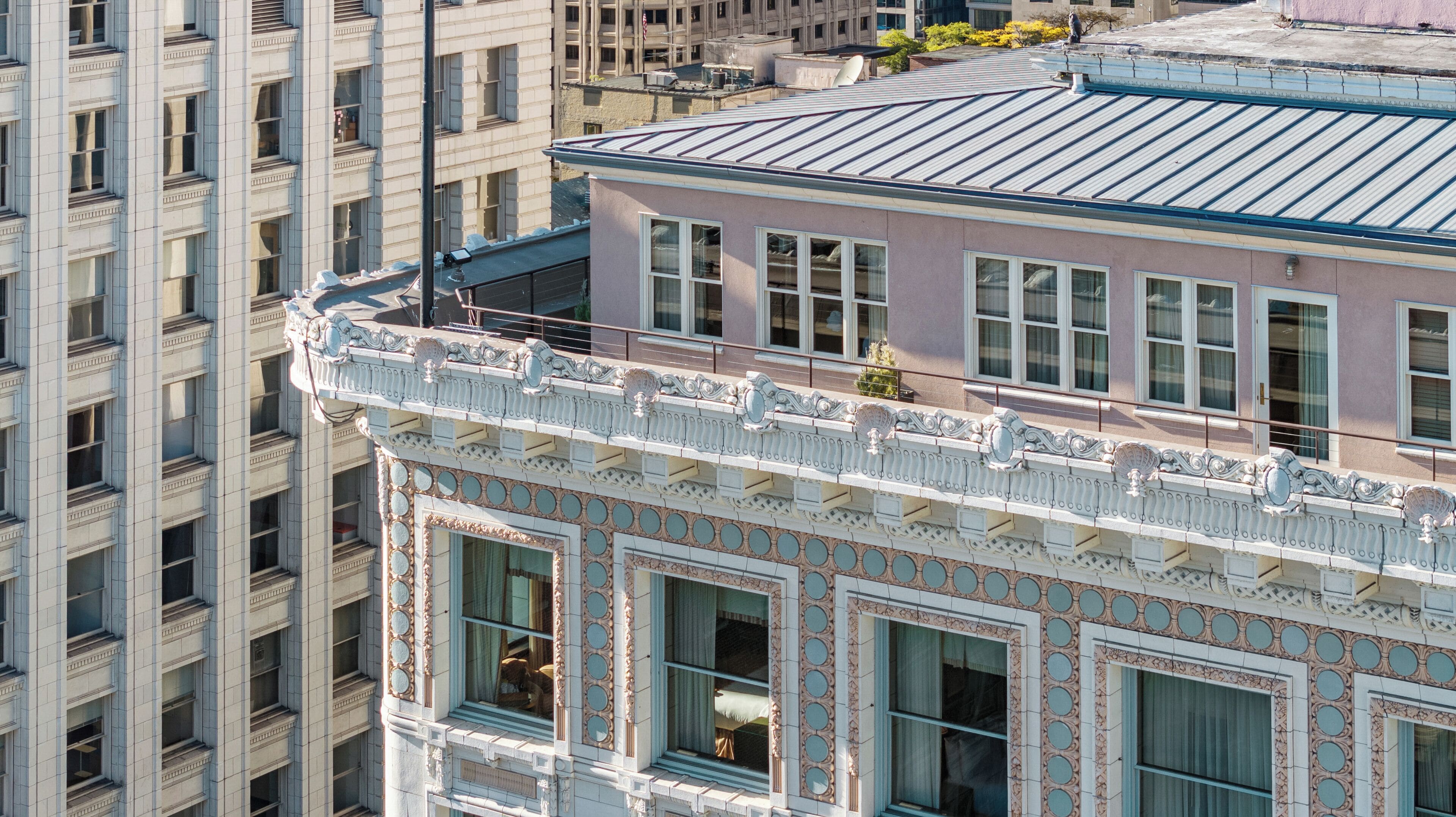 Un edificio de varios pisos con detalles arquitectónicos ornamentales, ventanas grandes y un techo plano.