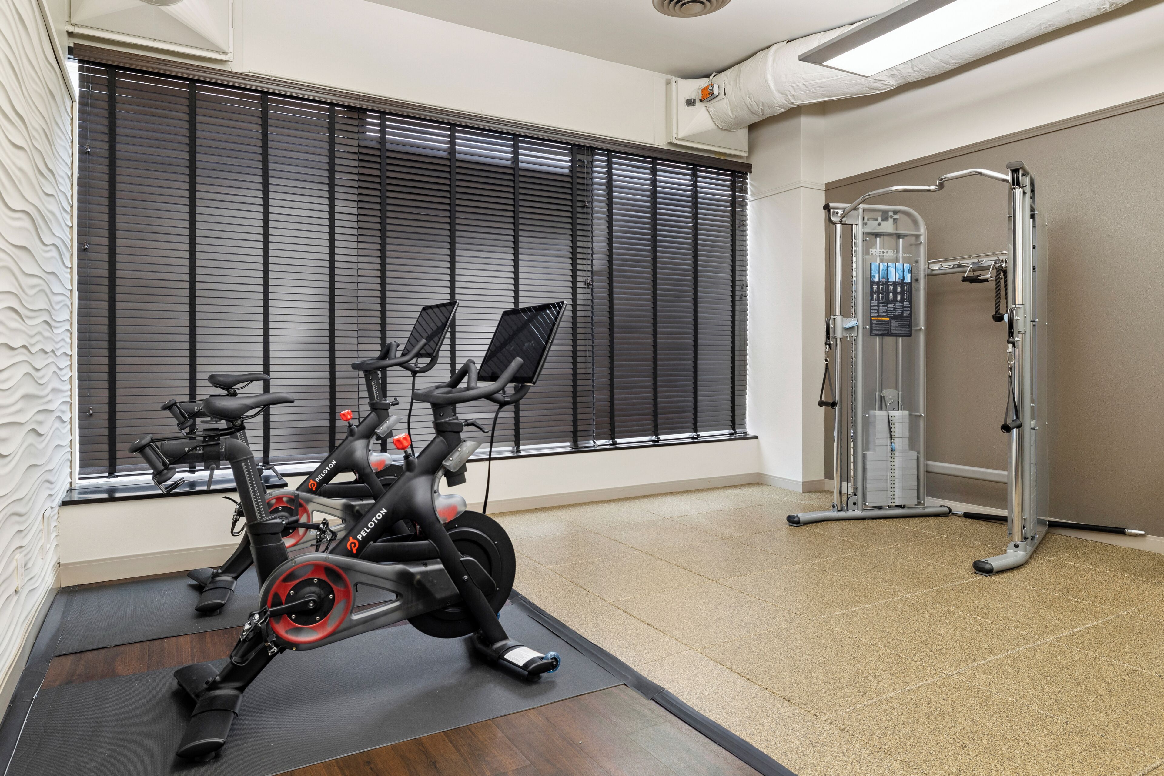 A gym with stationary bikes, a treadmill, and a weight machine.