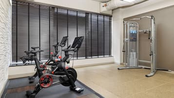 A gym with stationary bikes, a treadmill, and a weight machine.