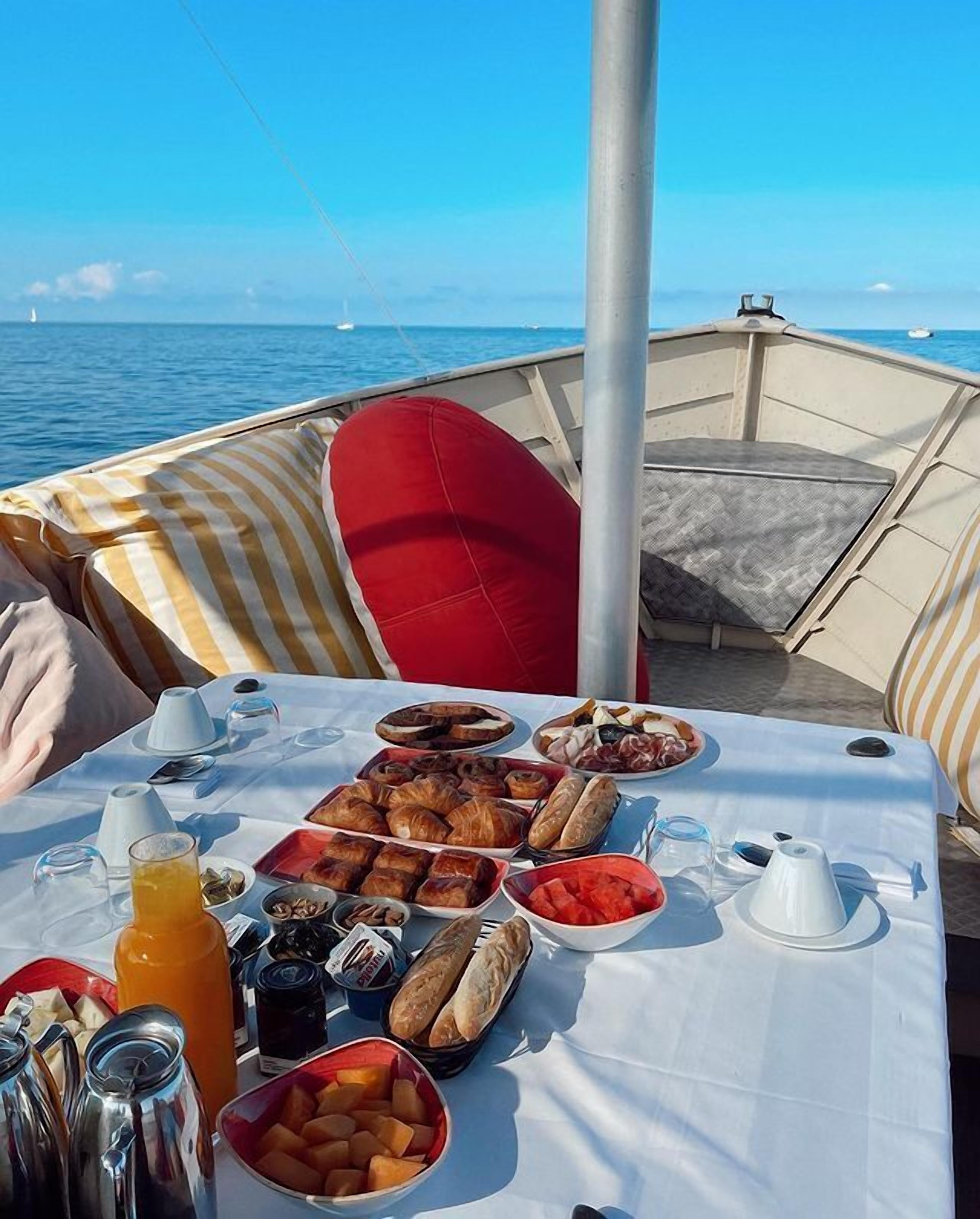 Una mesa lista para el desayuno en un barco, con vista al mar.