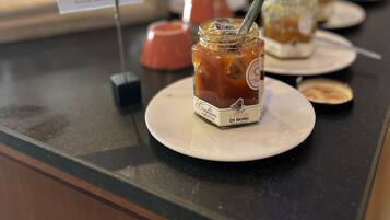 A dessert counter with jars of jam and a sign that reads "Marriage des dents".