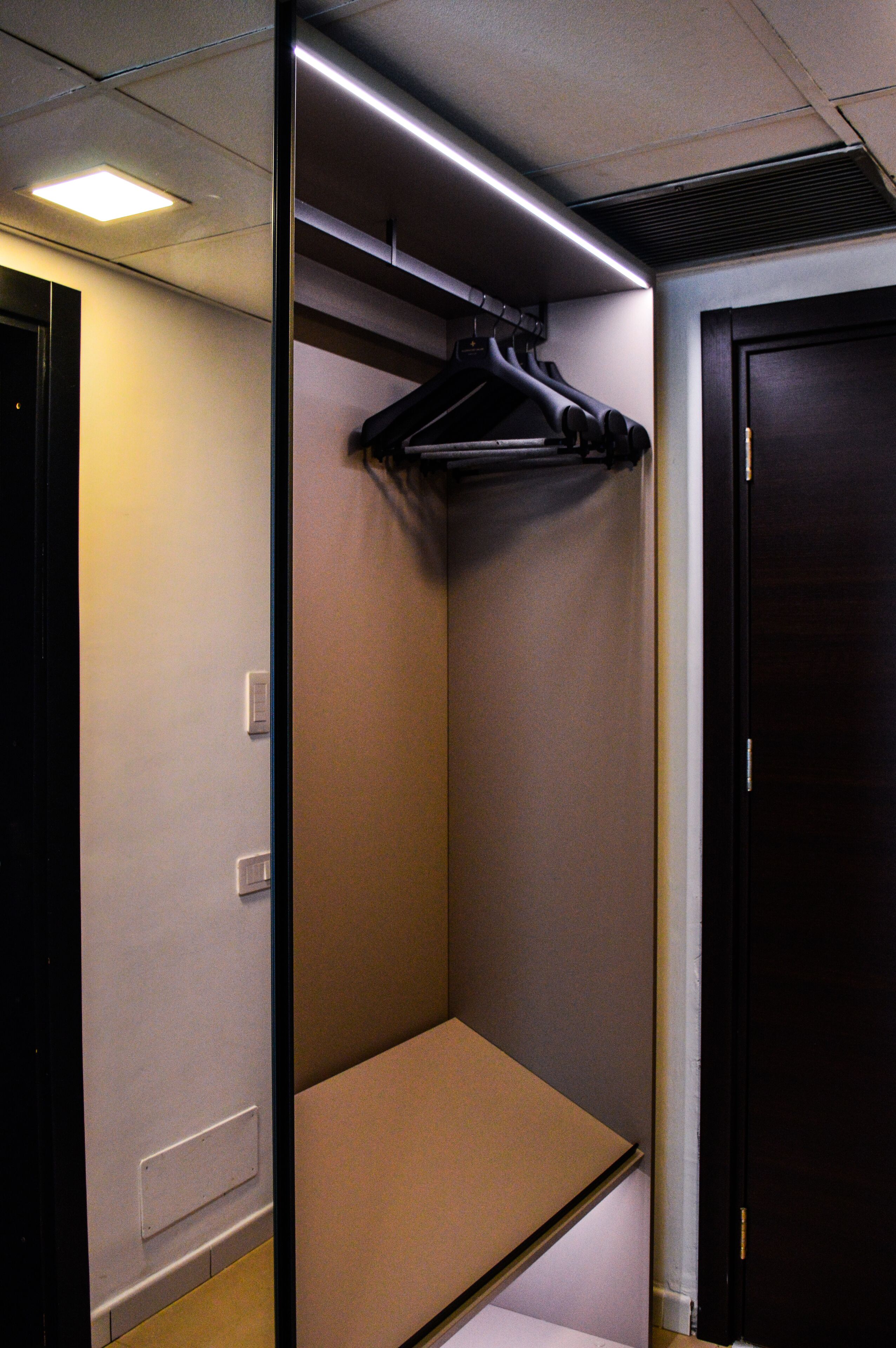Una habitación pequeña y cerrada con una sola puerta y una lámpara en el techo.