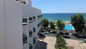 Un edifici modern amb zona de piscina i vistes al mar.