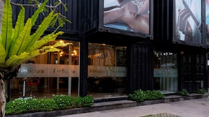 A building with multiple signs for services like manicure, pedicure, massage, and facial treatments. - Bali Island Villas and Spa Seminyak (Seminyak)