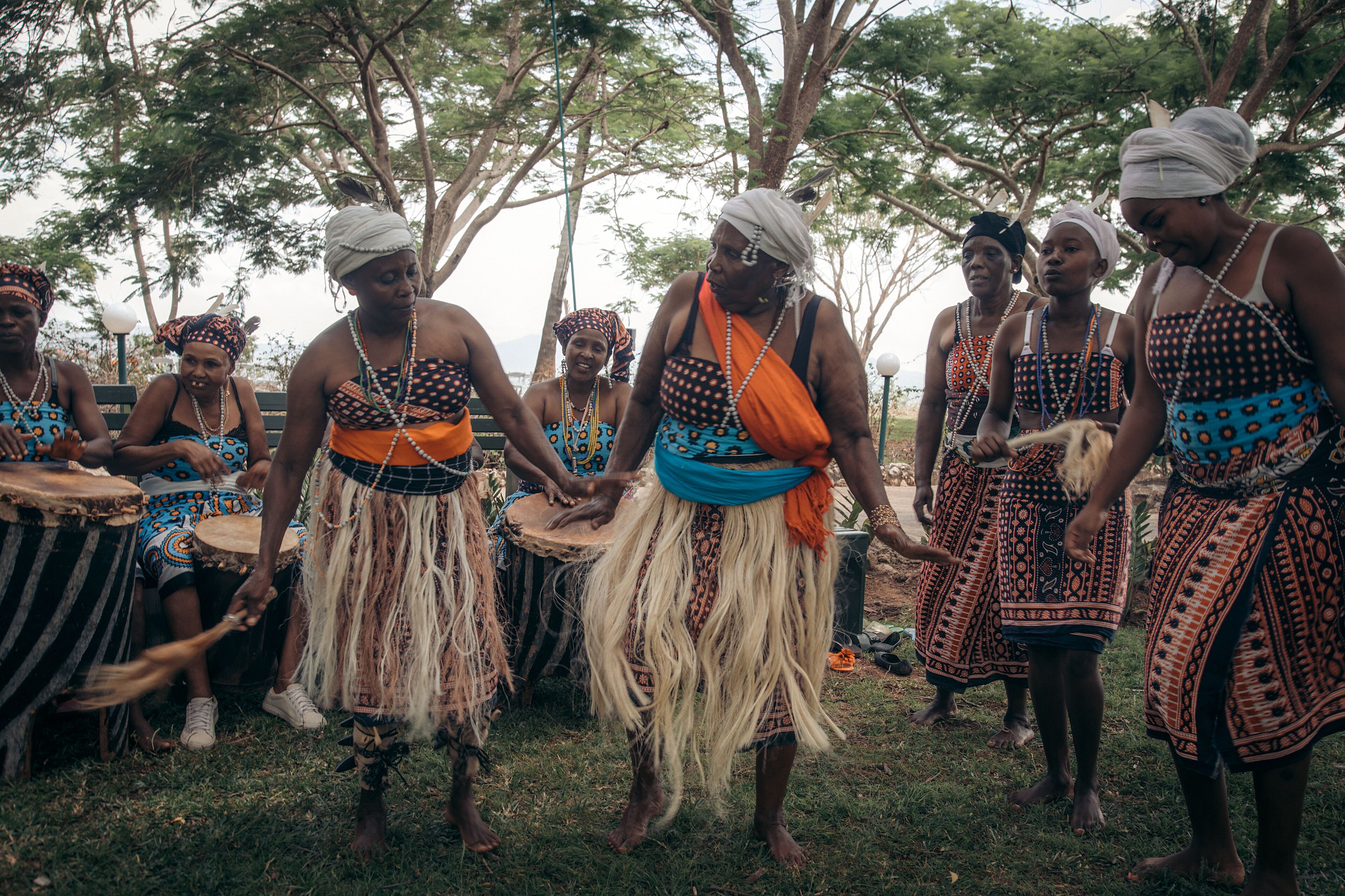 Un grupo de personas vestidas con atuendos tradicionales, reunidas al aire libre, posiblemente para un evento o ceremonia cultural.