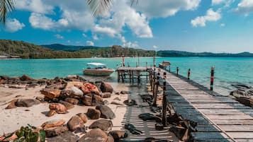 Privat strand, vit sandstrand, parasoller och strandhanddukar