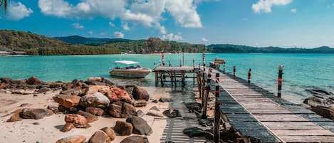 Privat strand, vit sandstrand, parasoller och strandhanddukar