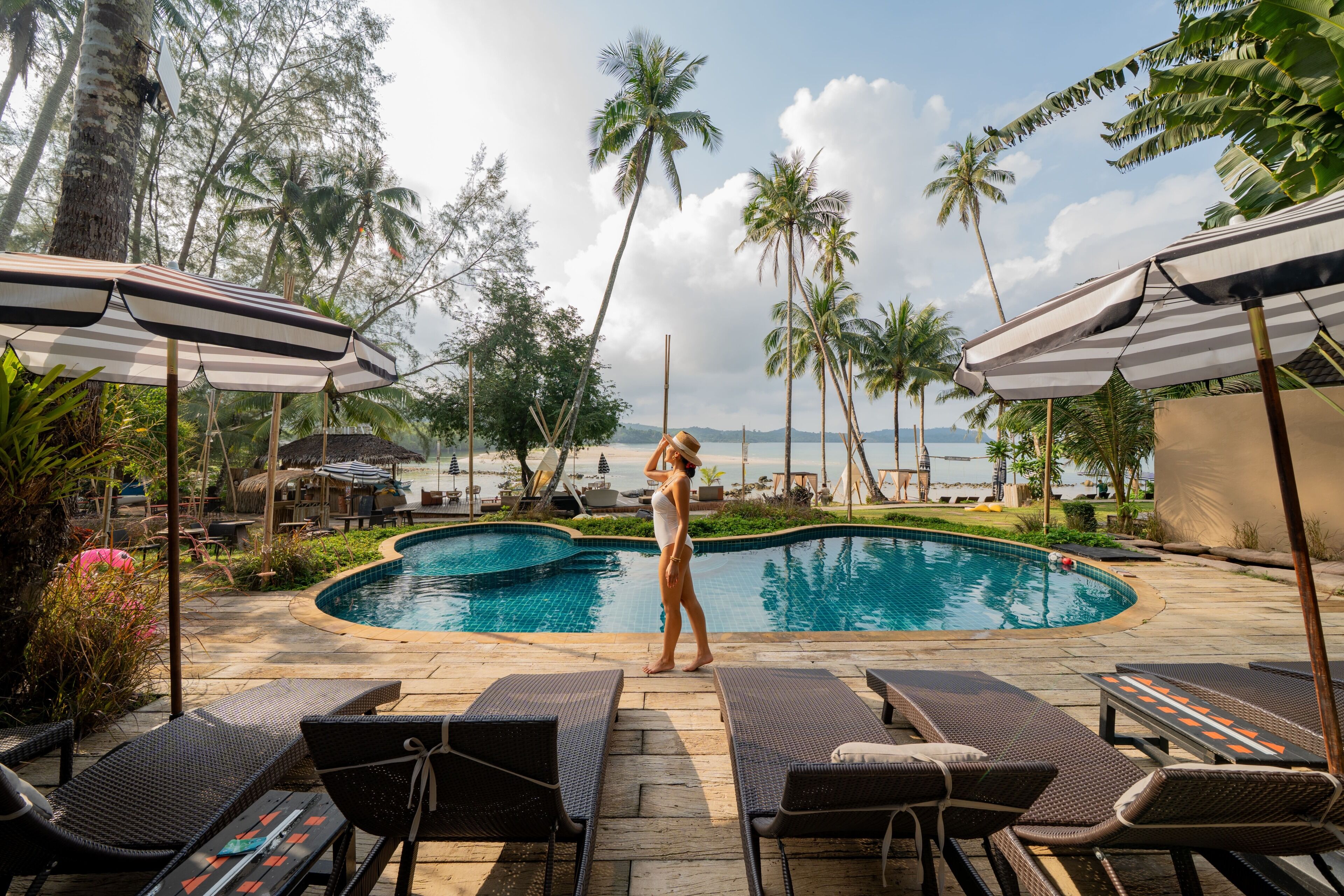 Una piscina al aire libre, sillones reclinables de piscina