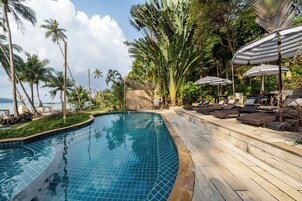 Una piscina al aire libre, sillones reclinables de piscina