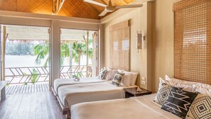 A hotel room with two beds, a ceiling fan, and a view of the beach.