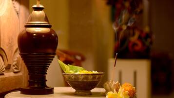 A table with a lamp, a bowl of flowers, and a decorative item.