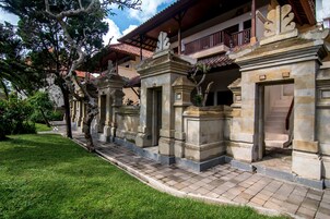 A traditional building with a tiled roof, stone pillars, and a balcony.