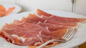 A plate of sliced cured meat with a fork.