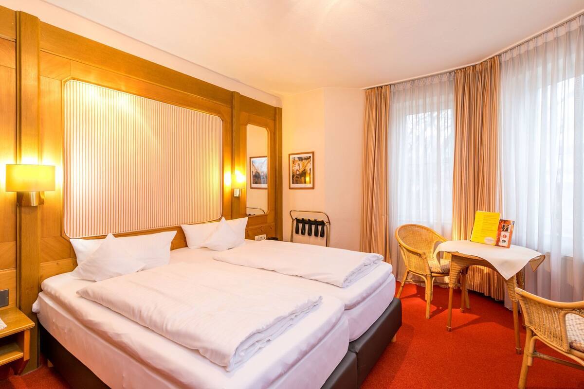 Ropa de cama de alta calidad y caja de seguridad en la habitación