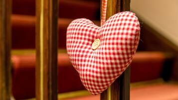 Adorno con forma de corazón y un botón, colgado de una barandilla de madera.