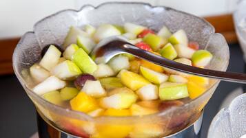 Un tazón de ensalada de frutas con una cuchara.