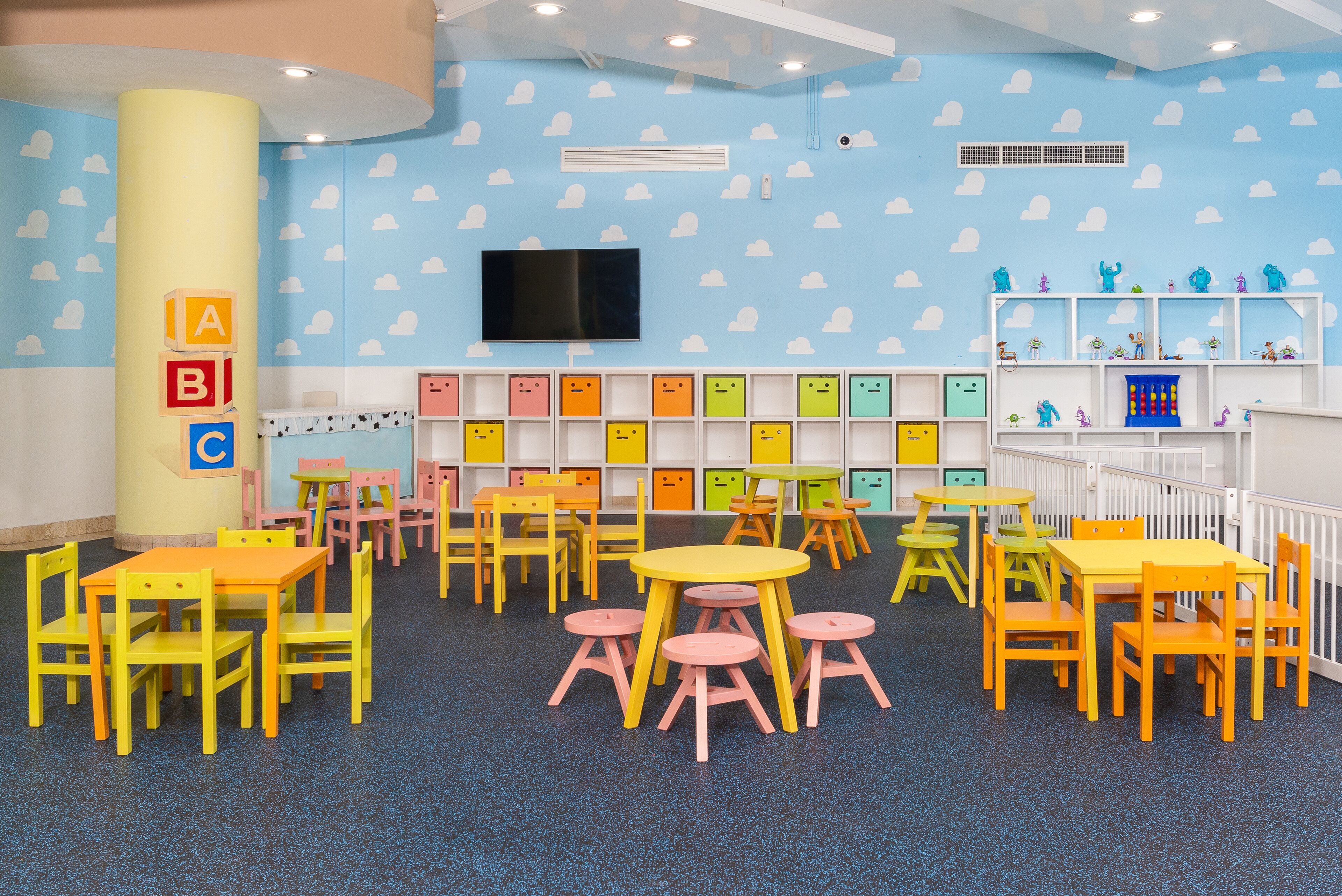A children's playroom with colorful furniture and alphabet storage boxes.