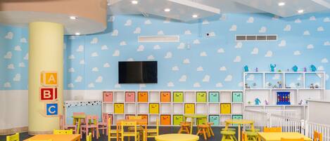 A children's playroom with colorful furniture and alphabet storage boxes.