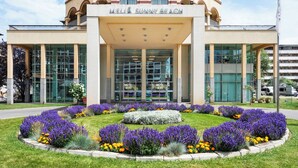 A hotel with a modern facade, large glass windows, and a central entrance.