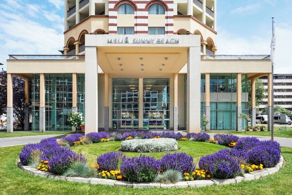 Un hôtel doté d’une façade moderne, de grandes fenêtres en verre et d’une entrée centrale.