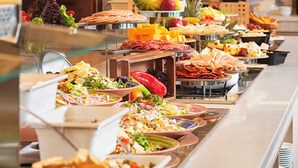 A buffet with various food items and a fruit display.