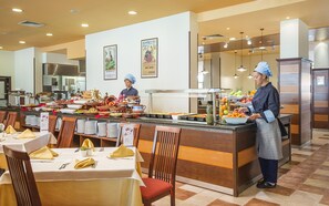 A buffet setup with various food items and a staff member serving. - Meliá Sunny Beach Resort (Sunny Beach)