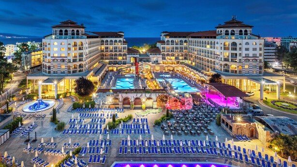 A hotel with multiple buildings, a swimming pool, and outdoor seating areas.