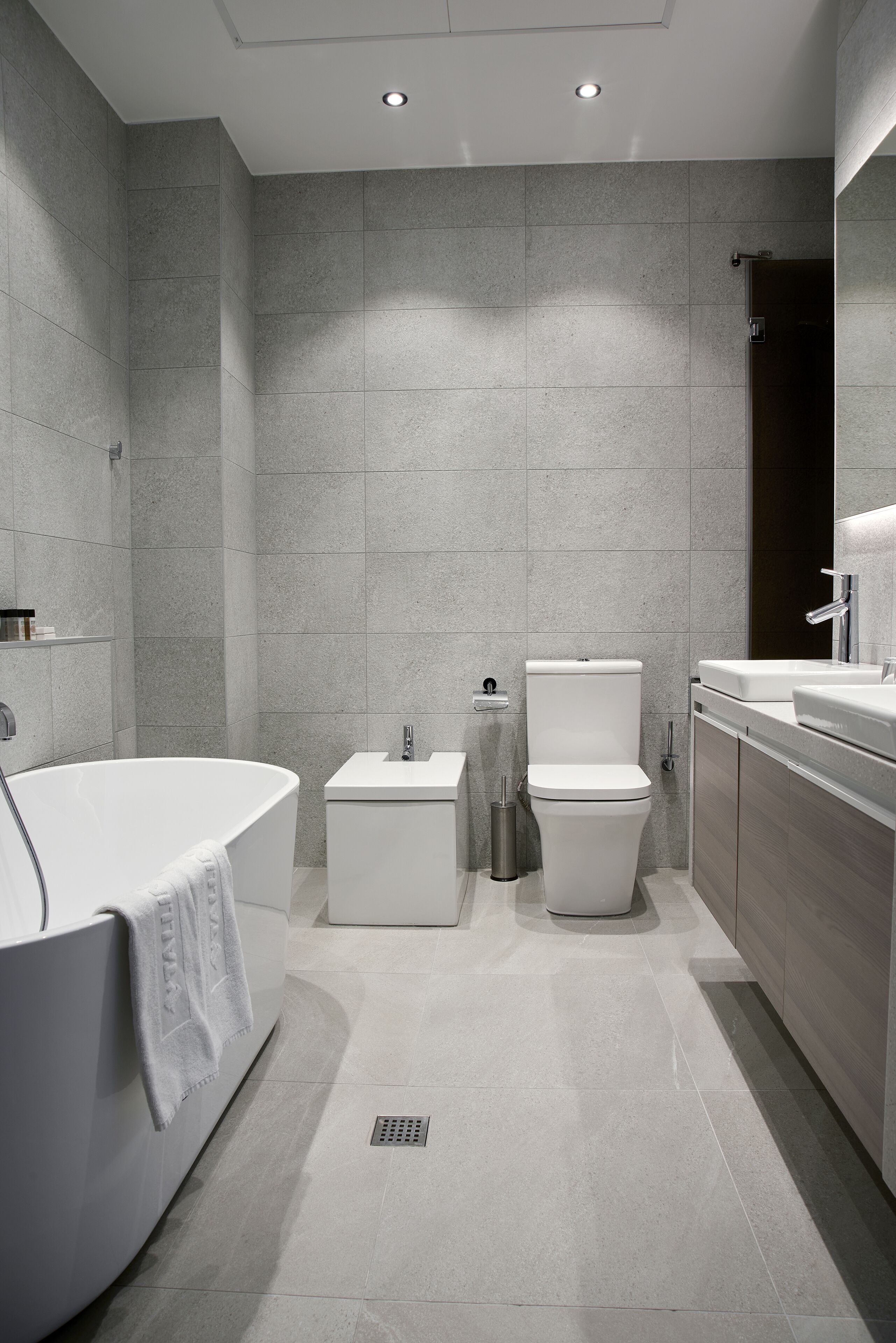 Ein modernes Badezimmer mit freistehender Badewanne, Toilette und Waschbecken.