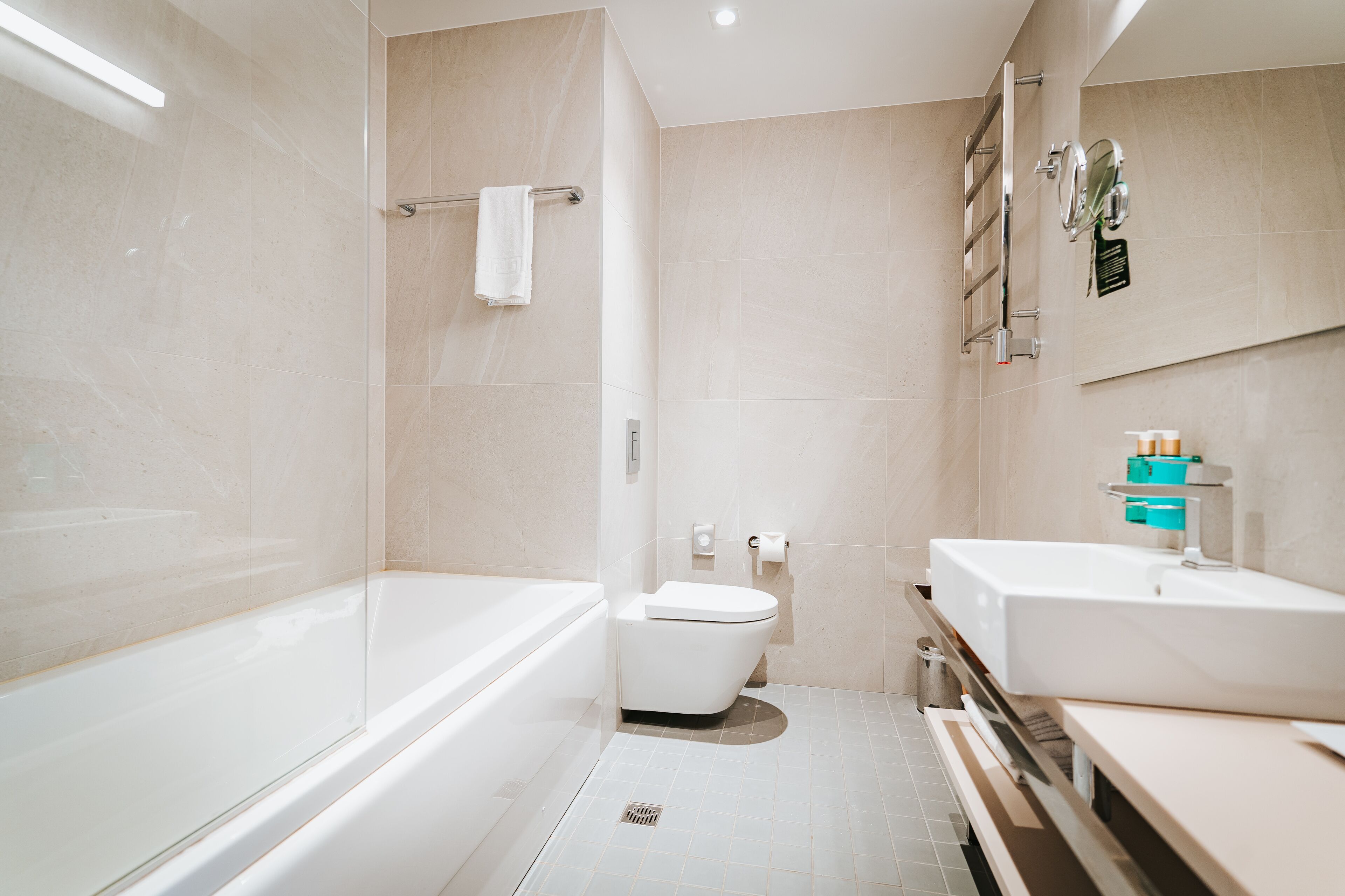 A modern bathroom with a bathtub, toilet, and sink.
