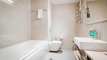 A modern bathroom with a bathtub, toilet, and sink.