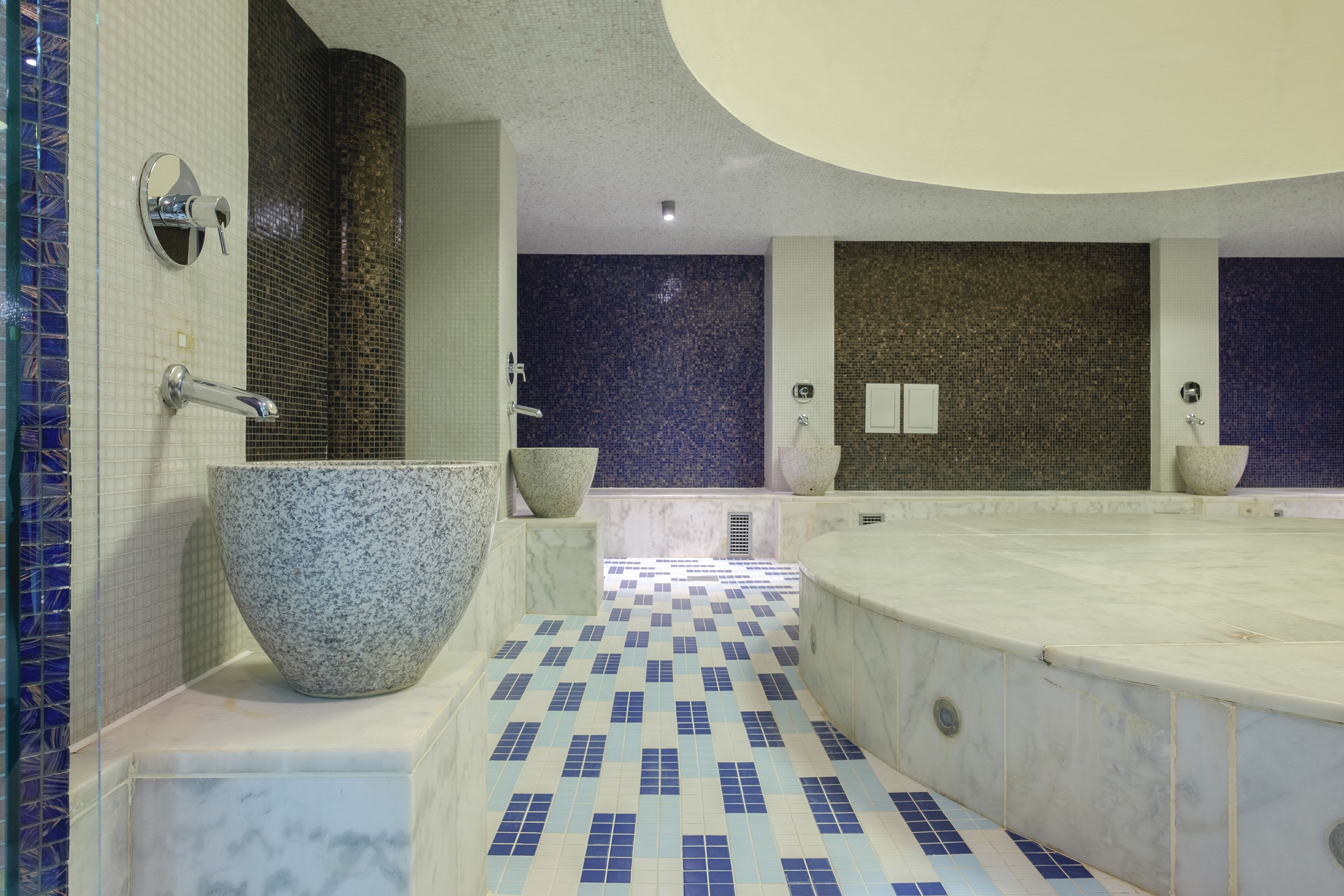 Een moderne badkamer met een vrijstaand bad, een groot waskom en een douchegedeelte.